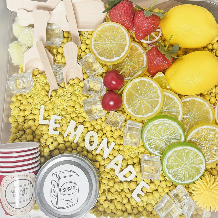 Container filled with lemons, limes, strawberries, and decorative elements with 'LEMONADE' text.